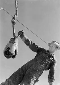 climax-molybdenum_co._swinging_a_reed_rock_bit_to_the_derrick_floor_by_the_thread_protector.jpg